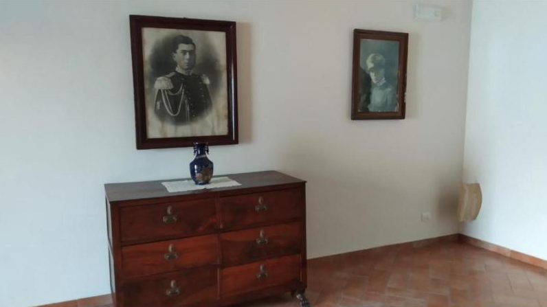 Comò antico e ritratti di famiglia alle pareti