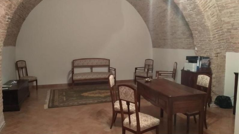 Sala comune con volta in mattoni, divanetto e sedie d’epoca