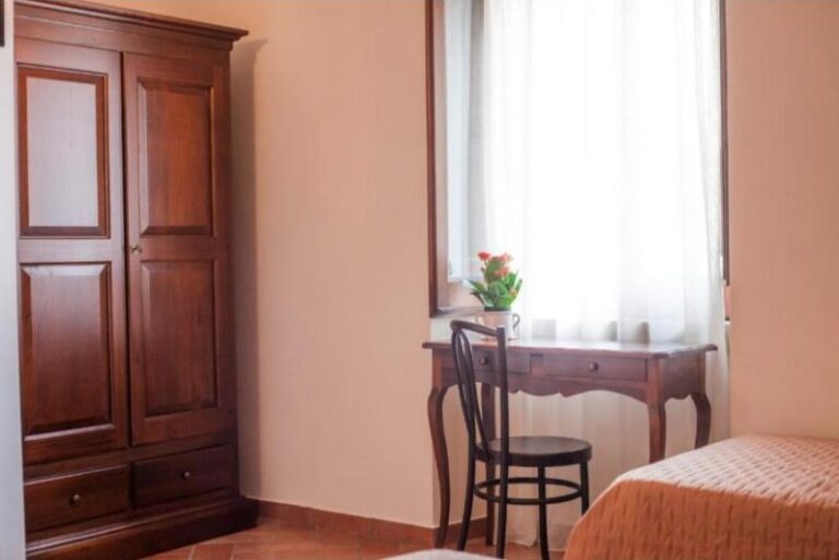 Scrittoio d’epoca accanto alla finestra e armadio in legno
